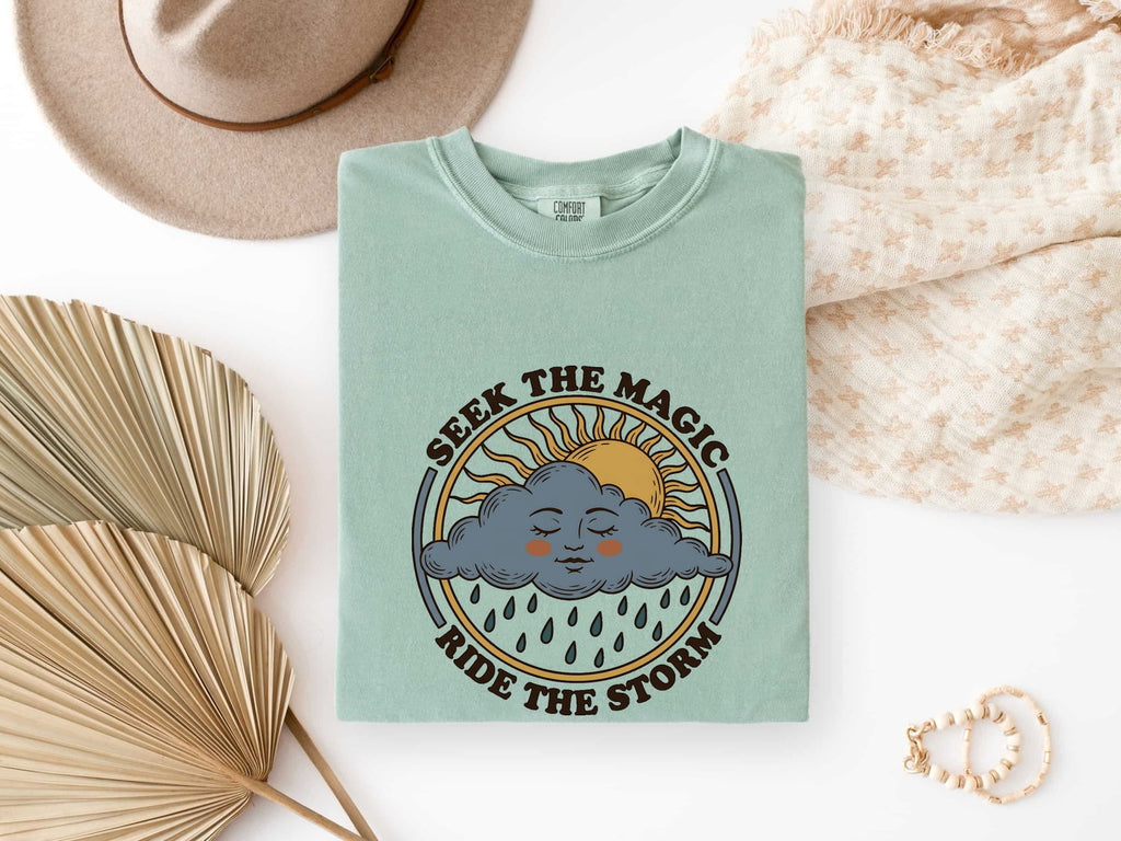 Seek the Magic Ride the Storm Tee – Inspirational Sun and Rain Graphic Tee