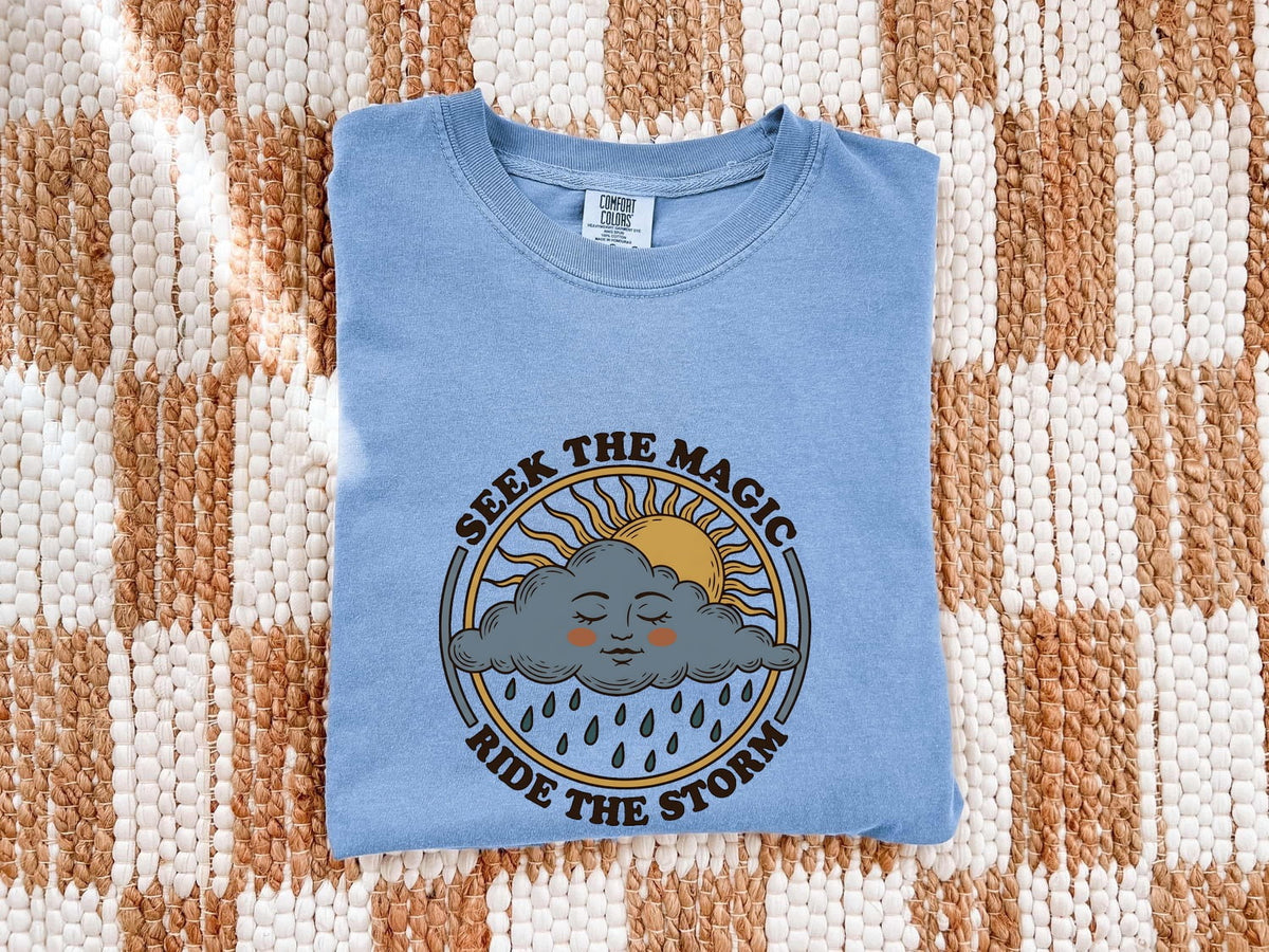 Seek the Magic Ride the Storm Tee – Inspirational Sun and Rain Graphic Tee